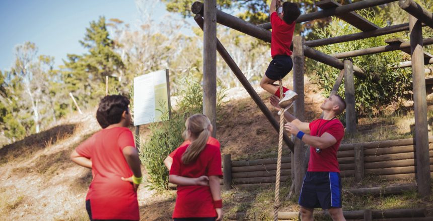 Trainer instructing kids in the boot camp on a sunny day