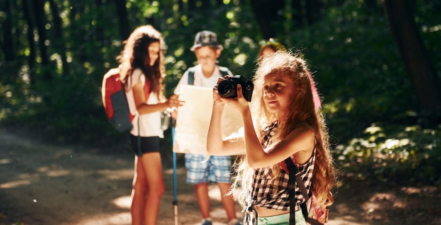 With touristic equipment. Kids strolling in the forest.